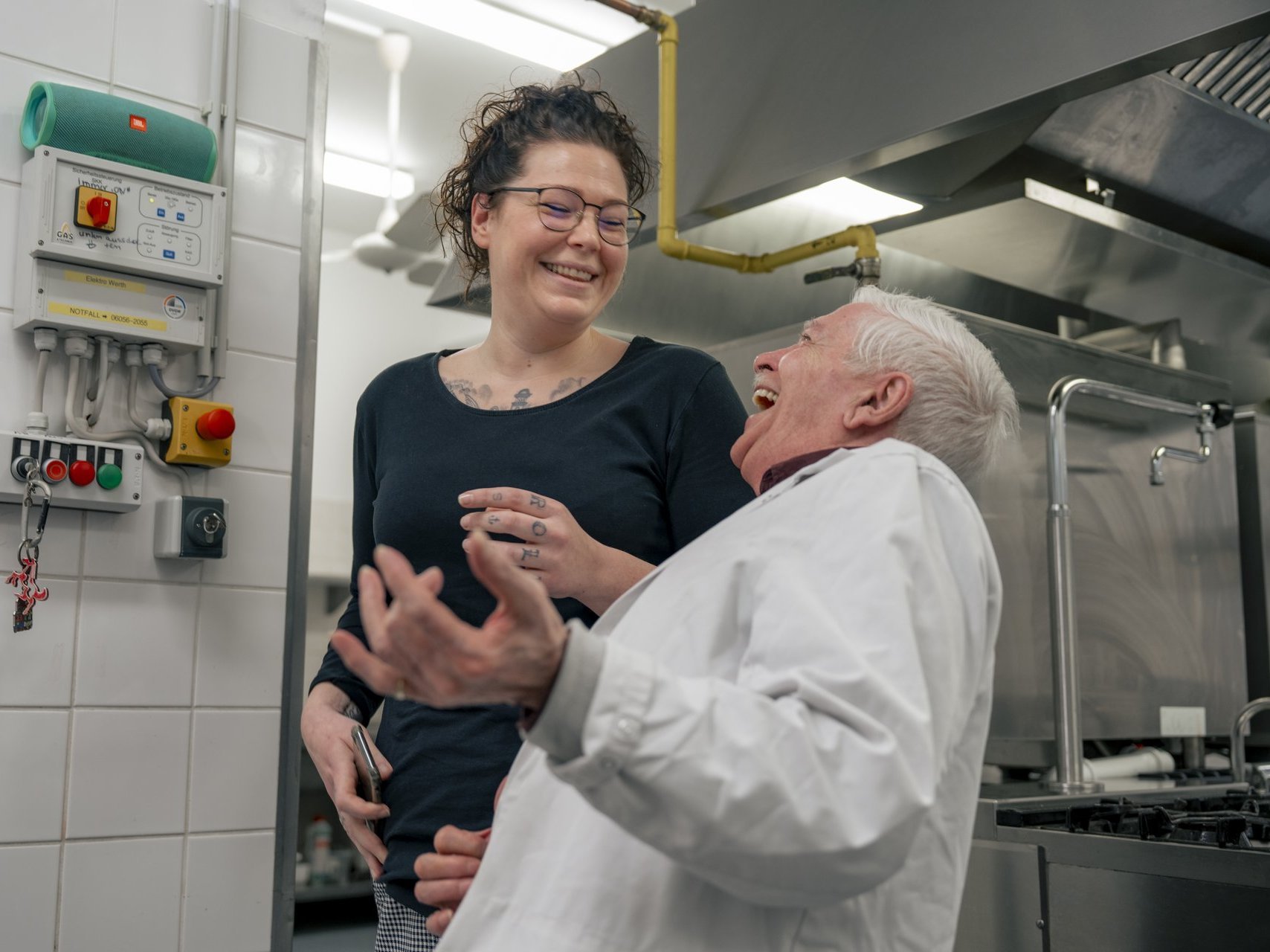 Zwei Personen die in der Küche lachen.