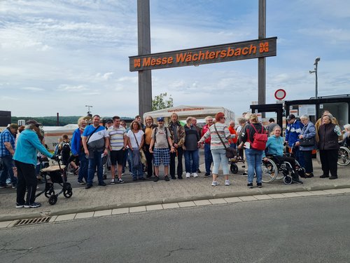 Vor dem Eingang zur "Messe Wächtersbach" - Eine Gruppe Männer und Frauen blicken lächelnd in die Kamera