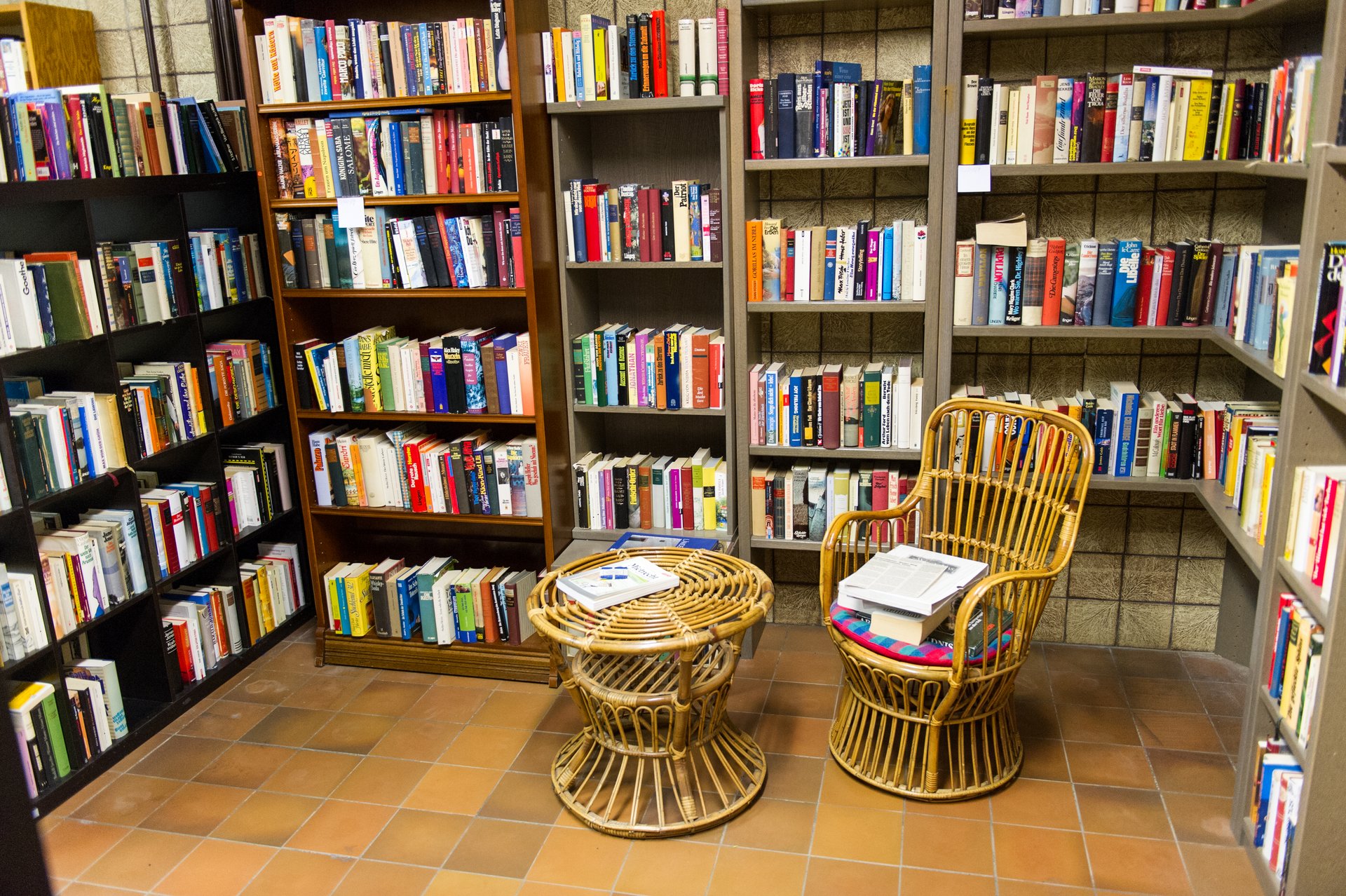 Bücherregale voll mit Büchern - davor steht ein kleiner Tisch und ein Stuhl